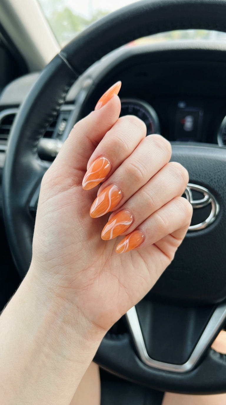 Apricot Jelly Swirl Almond Nails 2026 | Playful Vacation Juicy Swirl Apricot Jelly Almond nails: translucent apricot with opaque white abstract swirls. Almond summer nails 2026.