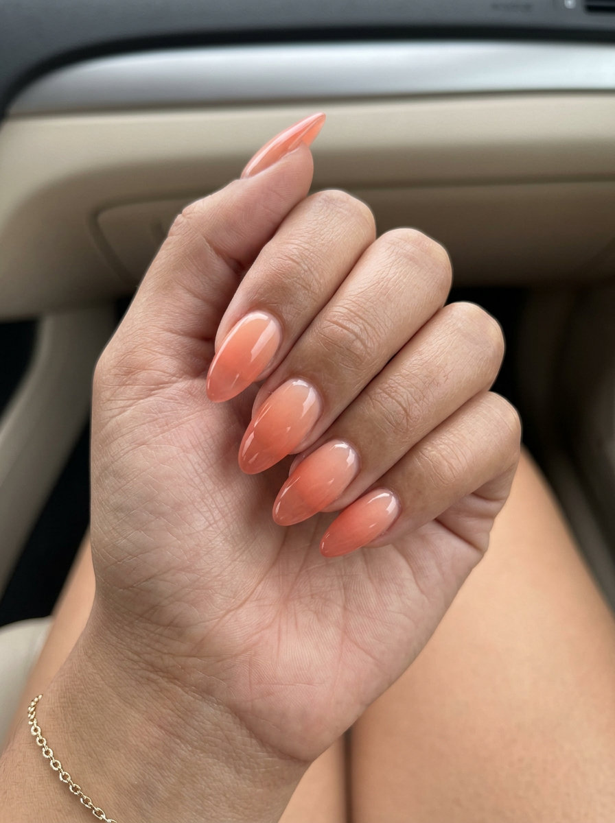 Peach Fuzz Jelly Ombre Sunset Nails: Romantic gradient of peach and coral jelly on long almond nails for summer 2026.