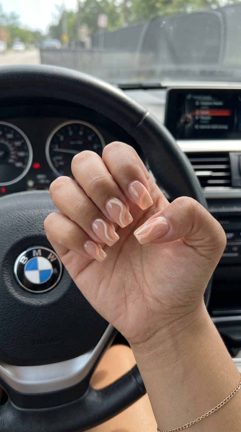 Bohemian nude nails with soft peach fuzz abstract swirls for relaxed summer 2026 days.