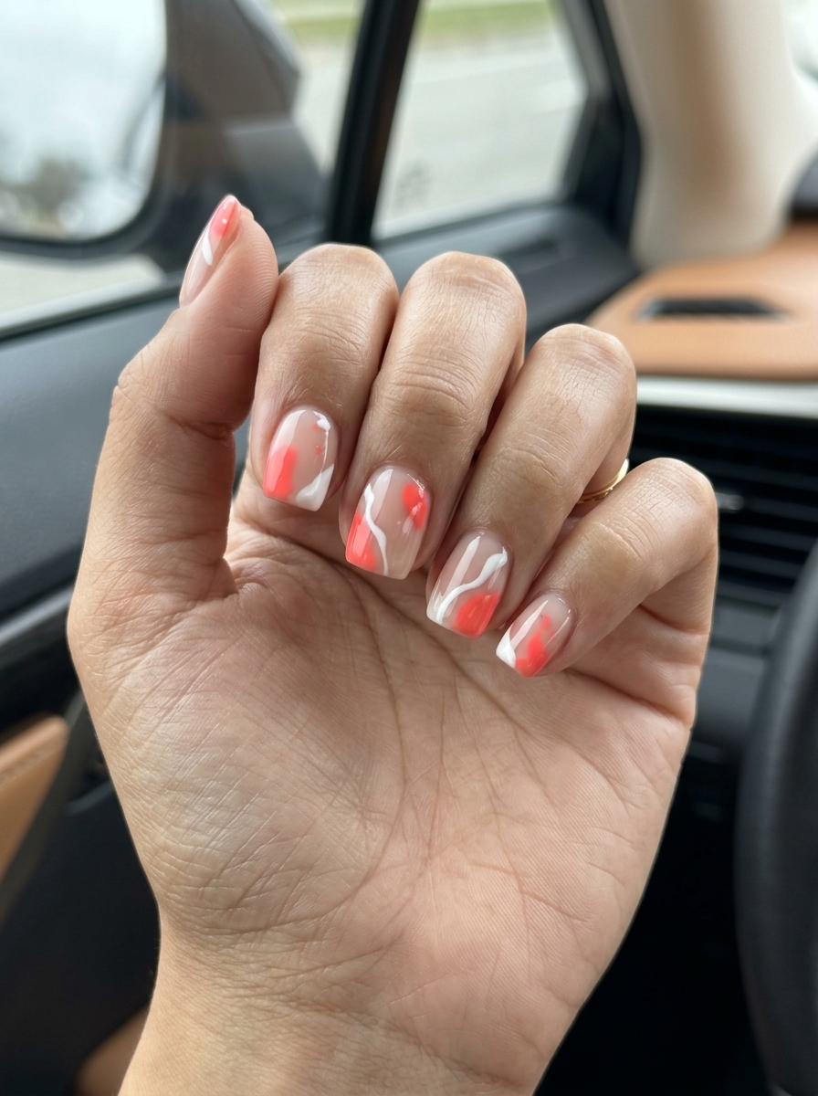 Coral Splash Abstract summer holiday nails 2026: vibrant coral & white art on nude base, short squoval shape.