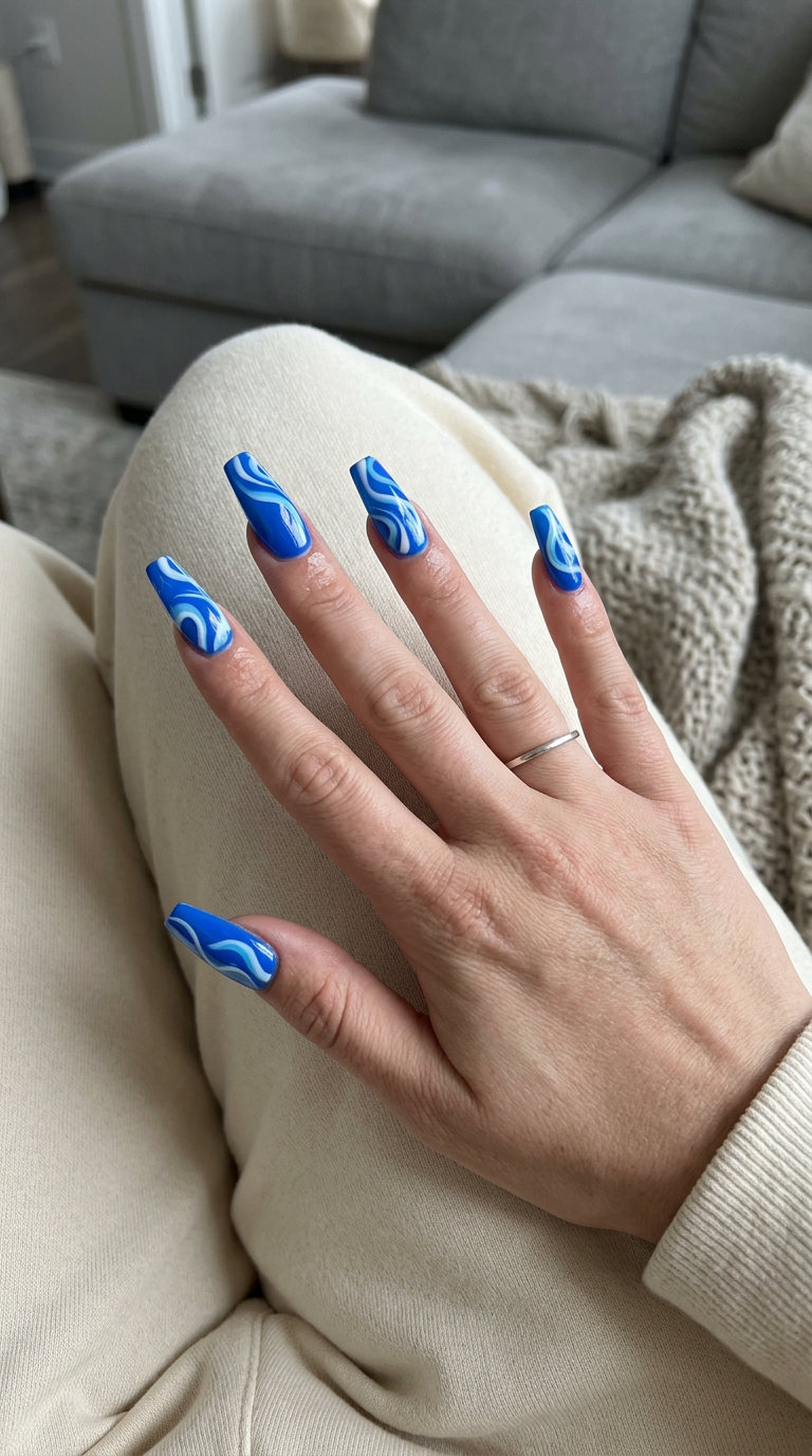 Electric blue airbrushed swirl nails for summer nails one color 2026, perfect for festivals and edgy fashion.